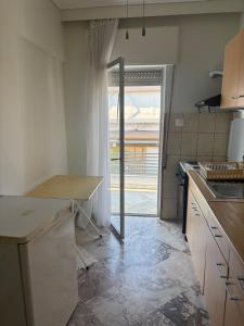 a kitchen with a counter and a door to a patio at Summer Holidays in Nea Kalikratia +4 photos