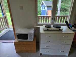 a microwave sitting on top of a dresser with a stove at Merikarviantupa in Pori