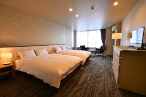 ein Hotelzimmer mit großem Bett und Schreibtisch in der Unterkunft ホテルグランリゾート蓼科 in Chino
