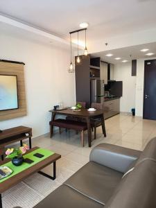 una sala de estar con un sofá y una mesa en Cozy Haven Middlemist's Red Suite at Trefoil, en Shah Alam