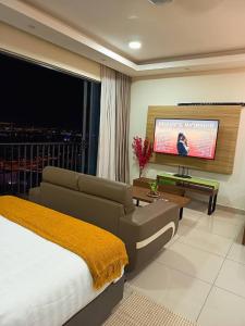 Un dormitorio con una cama y un televisor de pantalla plana. en Cozy Haven Middlemist's Red Suite at Trefoil, en Shah Alam
