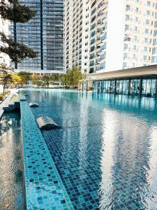 una gran piscina de agua en una ciudad con edificios altos en Cozy Haven Middlemist's Red Suite at Trefoil, en Shah Alam