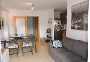 un soggiorno con un divano e un tavolo di vetro di Lcd - Alfons I a Montroig