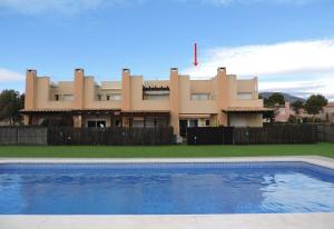 un edificio con piscina di fronte a una casa di Lcd - Alfons I a Montroig