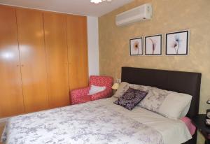 una camera da letto con un letto e una sedia rossa di Lcd - Alfons I a Montroig Altre 18 foto