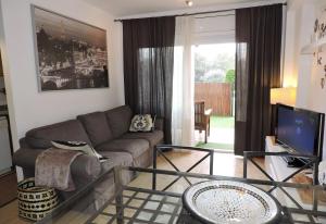 un soggiorno con un divano e un tavolo di vetro di Lcd - Alfons I a Montroig