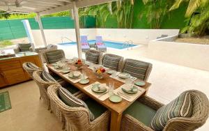 a wooden table and chairs in a patio with a pool at Jacks Place 3bd by ZenBreak in Saint Peter