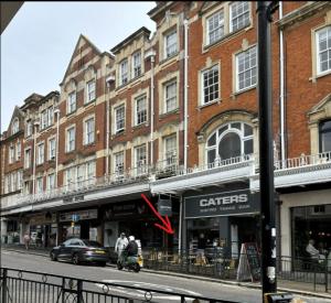 a building on a city street with cars parked in front at 1-Bed Apartment in Bournemouth centre in Bournemouth