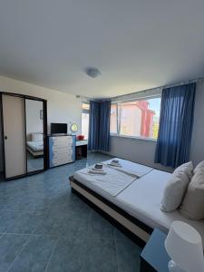 a bedroom with a large bed with blue curtains at Sarievi Holiday Home in Tsarevo