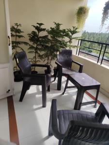 a group of chairs and tables on a balcony at Royal Service Apartment in Rājahmundry