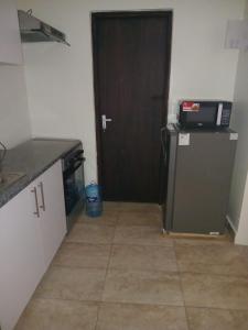 a kitchen with a black door and a refrigerator at 1255 Palm Ridge Estate in Vipingo