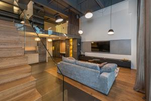 a living room with a couch and a tv at Parko namai-loftas in Kaunas