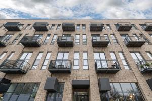 d'un grand bâtiment en briques avec balcon. dans l'établissement Parko namai-loftas, à Kaunas
