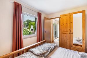 a bedroom with a bed and a window at Bungalow 73 in Zadelsdorf