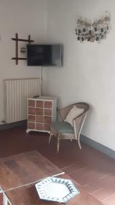 a living room with a chair and a tv on the wall at Celle di Lecchi Vigneto in San Sano