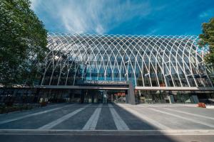 a large building with a lot of windows at Komandu Sporta Spēļu Halles viesnīca in Rīga