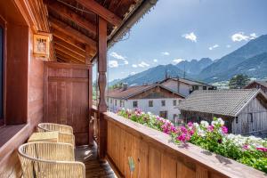 a balcony of a house with chairs and flowers at Hotel Alpenstolz in Mieders