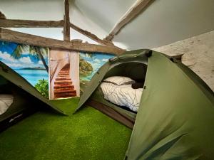 a green tent in a room with a painting on the wall at Les Flots de Barzan Appartement atypique avec vue mer in Barzan