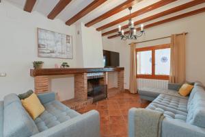 a living room with two blue couches and a fireplace at Riu Rau in Jávea