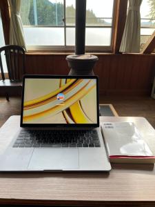 a laptop computer sitting on a table with a book at SchoolStay OKUYAHAGI-スクールステイ奥矢作 in Ena +12 photos