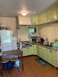 a kitchen with green cabinets and a table in it at Monet House モネハウス in Shimo-horado +74 photos