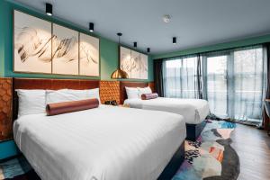 two beds in a room with green walls and windows at Naumi Auckland Airport Hotel in Auckland