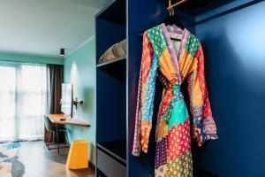 a room with a blue wall with a rack of clothes at Naumi Auckland Airport Hotel in Auckland +15 photos