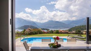 a room with a view of a pool and mountains at Villa Tivano, vista mozzafiato in Colico