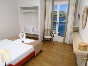 a hotel room with two beds and a balcony at Isalos Stay Andros in Batsi +17 photos