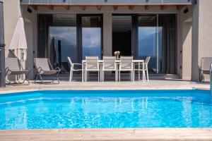 a table and chairs next to a swimming pool at Villa Tivano, vista mozzafiato in Colico