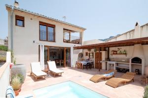 eine Terrasse mit Stühlen und einem Swimmingpool vor einem Haus in der Unterkunft Alojamiento rural La Mula en pleno corazón de la montaña de Alicante in Patró