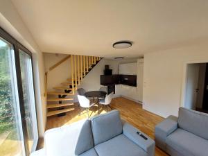 a living room with a couch and a staircase at Chalet Víchová se saunou in Víchová nad Jizerou