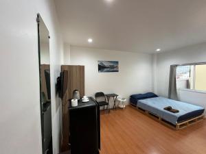 Un dormitorio con una cama y una mesa en una habitación. en mom's home, en Phuket