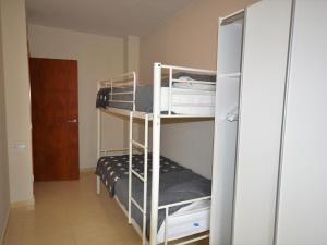 Zimmer mit 2 Etagenbetten und einer Tür in der Unterkunft Apto. céntrico en Sant Pere Pescador - Piscina, jardín, A/C, terraza grande, wifi - ES-89-88 in Sant Pere Pescador + 21 Fotos