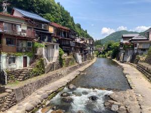 a river in a town with houses and buildings at Monet House モネハウス in Shimo-horado