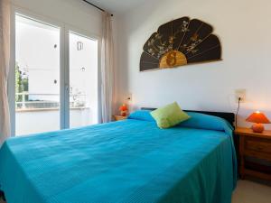 ein Schlafzimmer mit einem blauen Bett und einem Fenster in der Unterkunft Apartamento acogedor con piscina, WiFi y garaje cerca de la playa de La Farella, Llançà - ES-228-8 in Llança + 12 Fotos