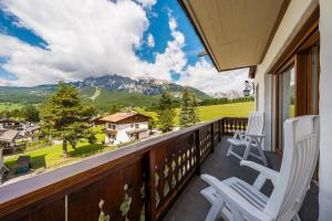 a balcony with two chairs and a view of a mountain at Chalet Belvedere - Dolomiti Skyline in Cortina dʼAmpezzo