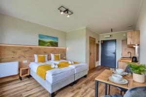 a bedroom with a large bed and a table at Magiczne Tarasy in Polańczyk