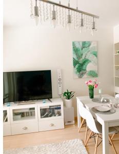 a living room with a tv and a table with chairs at Beautiful home close to the sea and city center in Helsinki