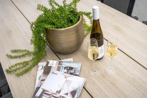a table with a bottle of wine and a plant at Kooparc in Giesbeek