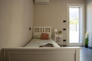 a bedroom with a large bed with a large window at Villa Tivano, vista mozzafiato in Colico +49 photos
