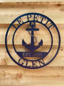 a sign on the side of a wooden wall with an anchor at Le Petit Glen Uplyme brand new accommodation in Uplyme