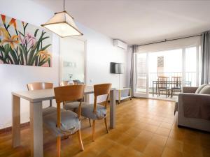 a living room with a table and chairs and a dining room at LLANÇÀ 8 LATERAL - Apartamento con vistas al mar, parking y Wifi. - ES-228-55 in Port de la Selva