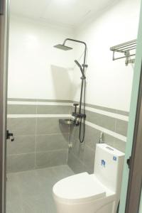 une salle de bain avec douche et toilettes dans une chambre dans l'établissement Euphoria Cat Ba Homestay, à Cat Ba