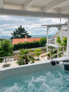 a hot tub on the balcony of a house at Bálics Vendégház in Pécs