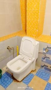 a bathroom with a white toilet in a room at The Misty Hotel in Bhatwāri