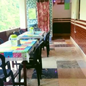 a dining room with two tables and chairs and a window at The Misty Hotel in Bhatwāri