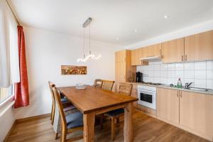 a kitchen with a wooden table and chairs in a room at Bungalow 71 in Stelzendorf
