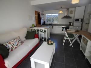a living room with a couch and a kitchen at Apartamento moderno, cerca de playa Les Tonyines, piscina comunitaria, terraza y WiFi - ES-228-141 in Llança