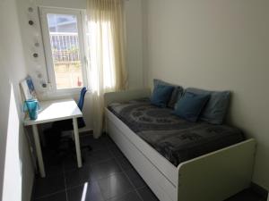 a bedroom with a bed with blue pillows and a window at Apartamento moderno, cerca de playa Les Tonyines, piscina comunitaria, terraza y WiFi - ES-228-141 in Llança